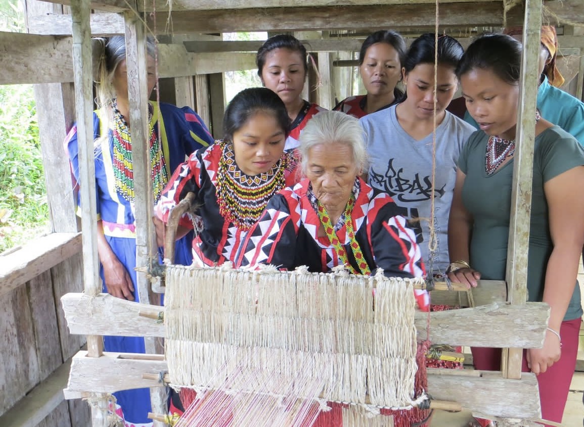 Women working together at a traditional wooden weaving loom